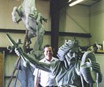 Artist beside the assembled horse-and-rider model with the sword raised