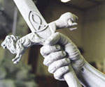 Sword-gripping hand and decorated crossguard viewed from the side
