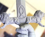 Close-up of the decorated sword crossguard above the gripping hand