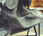 Close-up of the rider's sculpted boot and flowing garment