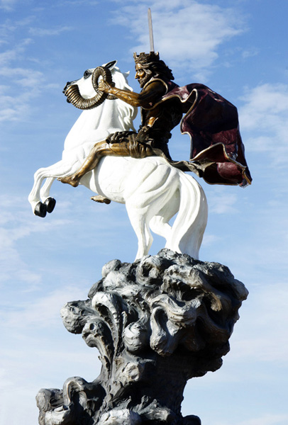 The Coming King® rider and white rearing horse above its dark swirling base