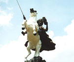 Low-angle front view of the white horse and crowned rider in The Coming King®
