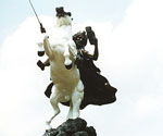 Low-angle front view of the white horse and crowned rider in The Coming King®
