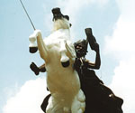 Low-angle front view of the white horse and crowned rider in The Coming King®
