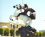 Angled courtyard view of The Coming King®, showing the horse's raised front legs and rider's cloak