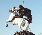 Low-angle view of The Coming King® showing the rider, flowing cloak and white horse