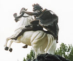 Low-angle view of The Coming King® showing the rider, flowing cloak and white horse