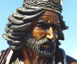 Close-up of the crowned rider's bronze face and flowing hair in The Coming King®