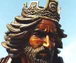 Close-up of the crowned rider's bronze face and flowing hair in The Coming King®