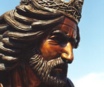 Close-up of the crowned rider's bronze face and flowing hair in The Coming King®