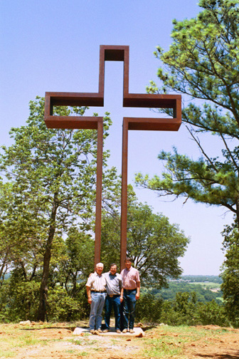 Visitors standing beneath the first large model of The Empty Cross™ outdoors