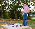 Man standing at the prepared concrete foundation for the cross