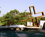 Large steel cross lying on a flatbed trailer outdoors