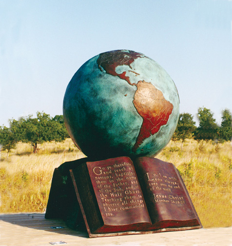 The Great Commission® globe-and-Bible sculpture in an open landscape