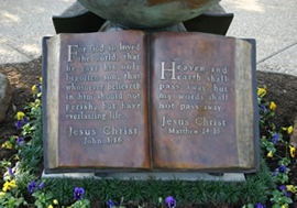 Close-up of the inscribed Bible pages beneath The Great Commission® globe