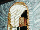 Detail of a stone arch and wooden shelving