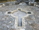 Cross-shaped inset within a stone prayer patio