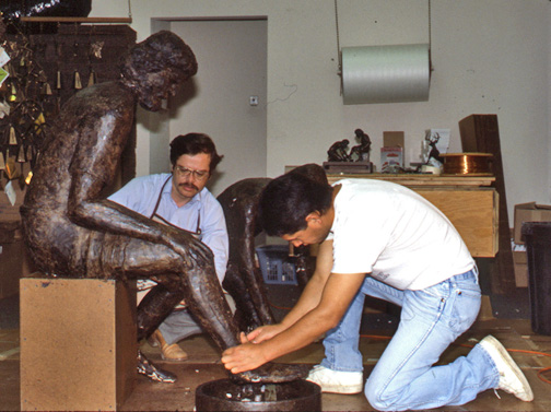 Two sculptors working on the feet and basin of the large Divine Servant® model