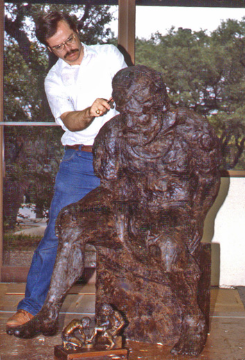 Artist working on the dark wax seated figure outdoors