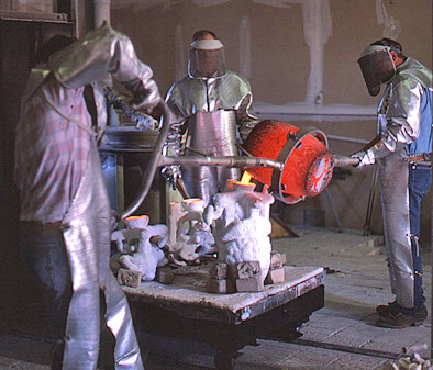 Workers pouring glowing metal into prepared molds