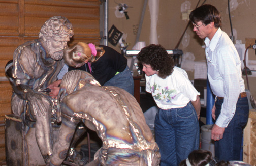 Workers gathered around Divine Servant® during metal finishing