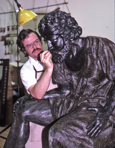 Max Greiner beside the seated wax figure, resting his cheek on his hand