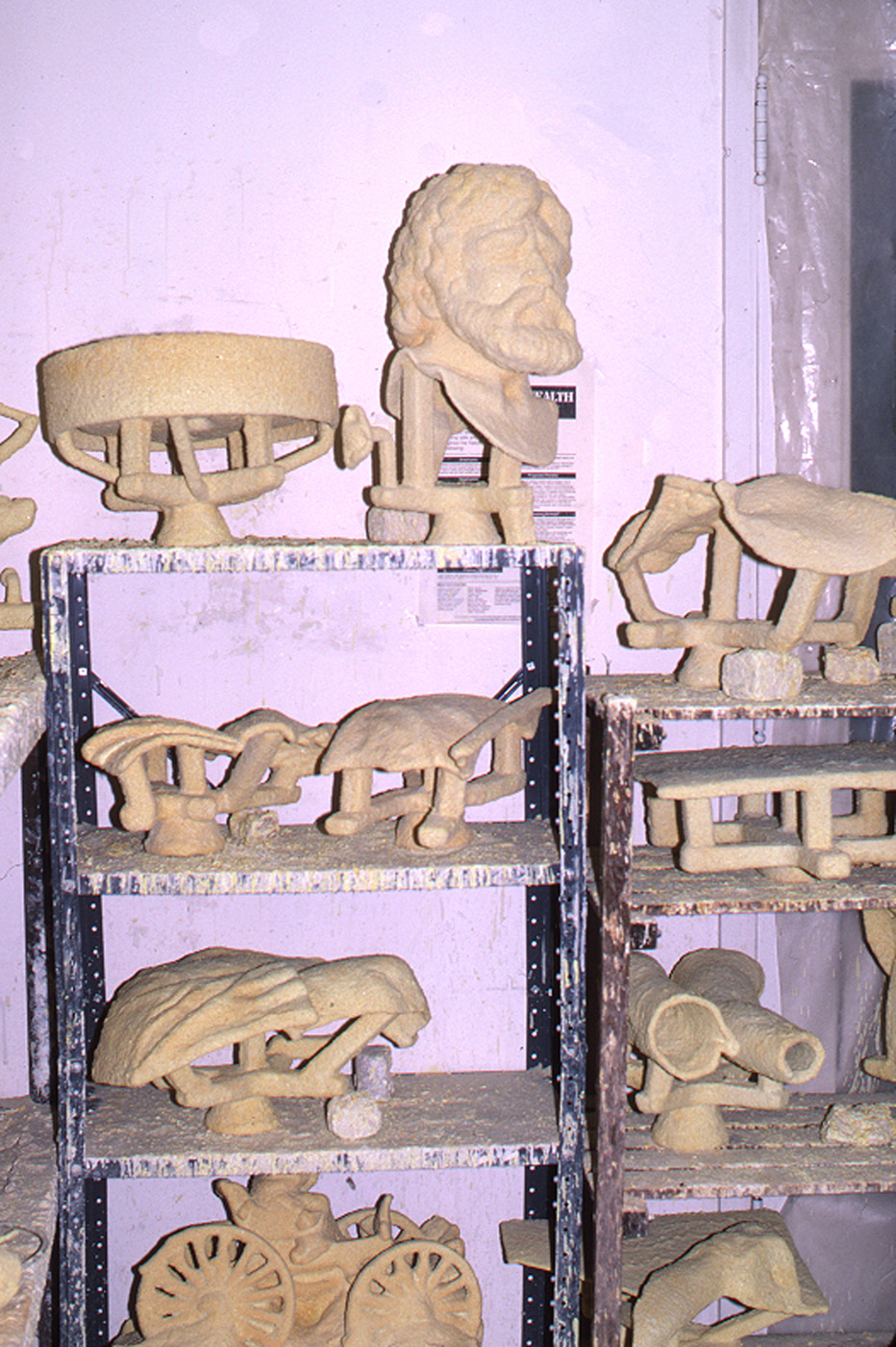 Pale ceramic mold sections arranged on a foundry rack