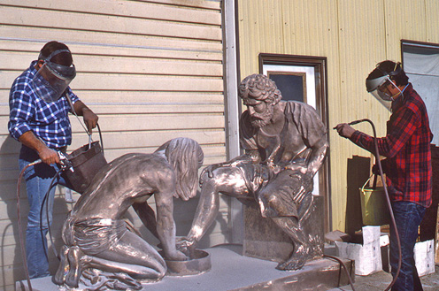 Workers applying the final finish to the two Divine Servant® figures