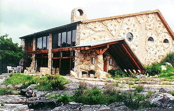 Greiner stone-and-timber studio home among rocks and garden plants