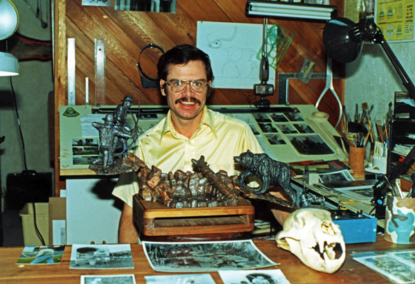 Max Greiner holding a wildlife bronze sculpture in his studio