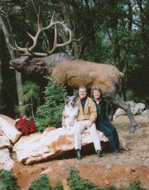 Couple posing beside a mounted elk display