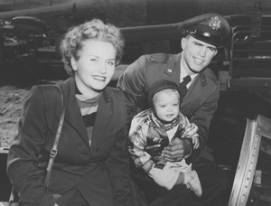 Baby Max Greiner sitting with his parents in a black-and-white family photograph