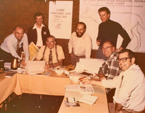 Men gathered around a table at an archery association meeting
