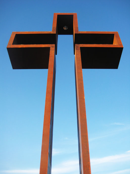The Empty Cross rising into a blue sky at the Sculpture Prayer Garden