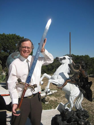 Max Greiner holding a sword beside a small horse-and-rider sculpture