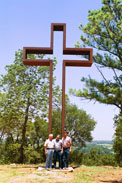 Visitors beside The Empty Cross™ sculpture